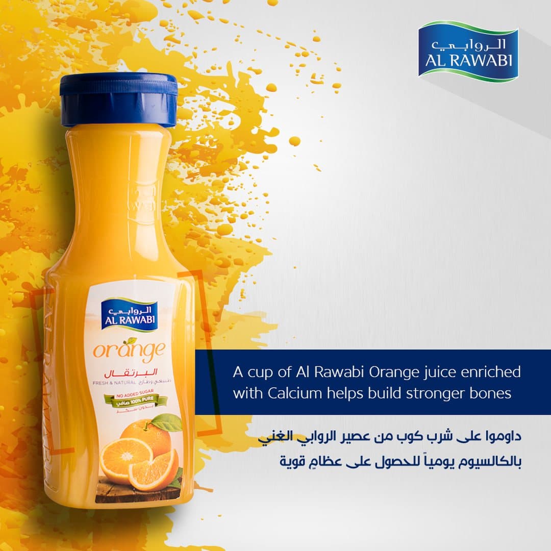Al Rawabi orange juice bottle against a yellow splash, with a navy caption panel about calcium and bones, in English and Arabic